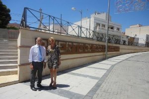 El alcalde y la concejal, ante el cartel que identifica al barrio.tyle>.apqj{position:abso