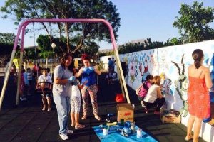Padres y madres decorando el muro que da nombre al Parque infantil Bob Esponja en Gádortyl