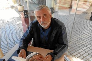 Pedro Blanco Naveros ojea un ejemplar de la obra en el Paseo Marítimo. tyle>.apqj{position