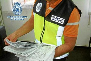 Un policía muestra documentación decomisadax,au