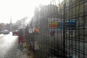 El coche ardiendo en el momento en el que los dos chicos (a la derecha) trasladan al conductor.</tit