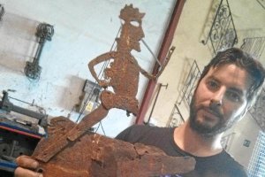 Uno de los restauradores con la figura antes de ser arreglada.e