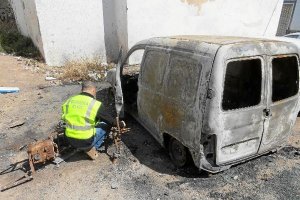 Un agente analiza los restos de la moto y del coche totalmente calcinados.tyle>.apqj{posit