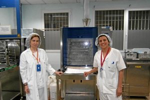 Responsables Adela Berenguel y Mª Ángeles Lucena, junto a una de las máquinas de lavado de la Centra