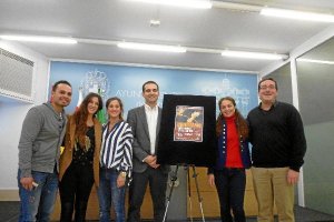 Foto de falmilia de varios organizadores y artistas con el cartel del concierto.tyle>.apqj
