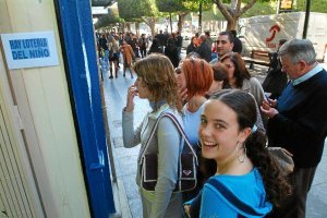 Un gripo de personas hace cola ante una administración almeriense para comprar lotería en una imagen