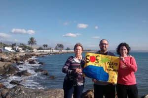 Vecinos fotografiándose con el cartel reivindicativo