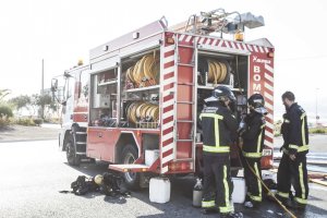 Bomberos del Poniente preparando y revisando el equipamiento del camión.