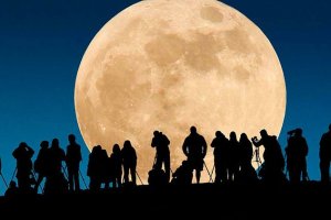 Una inmensa luna con numerosos espectadores.