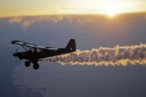 Una avioneta lanzando sustancias sobre los campos.