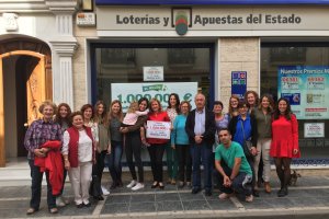 Responsables y personal de la Administración Nª 2 de Tíjola posan con el cartel del premio vendido junto a amigos y familiares.
