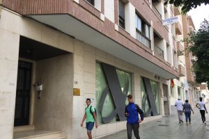 Dos adolescentes pasan por delante del portal donde vivía la familia