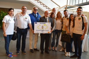 Antonio Bonilla y Vanesa Lidueña posan con el certificado de la candidatura de Vícar junto al responsable de ACES Europe.