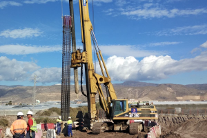La grúa coloca los pilotes para la cosntrucción del puente.