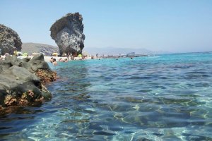 Bañistas disfrutando del agua y la arena en un día de playa en las costas de Almería.