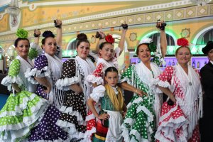 La Agrupación Folklórica Alcazaba preparada para bailar sobre el escenario de la Caseta Municipal.