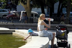 Una mujer combate el calor bebiendo agua.