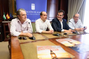 Los responsables de la organización del festival junto al cartel del mismo, sobre la mesa.