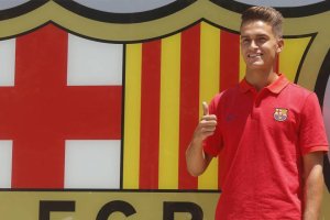 El jugador azulgrana posando junto al escudo.