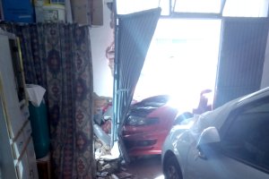 El vehículo se empotró en la cochera de una vivienda.