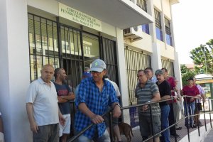 Usuarios del centro social de jubilados de las 500 Viviendas en la barandilla de la entrada.