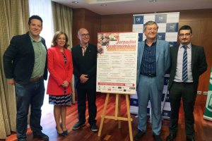 Junto al cartel de las jornadas, promotores y organizadores del evento.