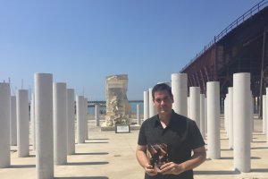 Juan Marín con su libro en el monumento a las víctimas almerienses de Mauthausen.
