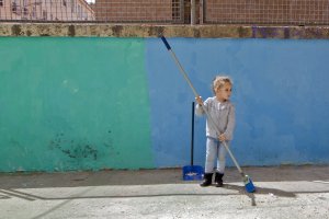 Una niña barre la calle de La Chanca, donde es ‘cazada’ por el fotógrafo.