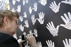 Una mujer muestra su apoyo a las víctimas del terrorismo durante un acto.