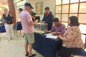 Uno de los militantes socialistas que votan hoy, depositando su papeleta.