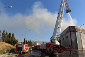 Bomberos del Poniente durante las tareas de extinción del incendio en una nave en Adra.