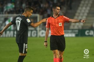 El árbitro le enseña a Corpas el camino del vestuario.