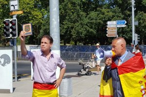 Meylan (izquierda) muestra una placa de los Mossos en una concentración a favor de la unidad de España en una plaza de Ginebra.