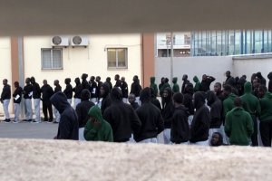 Inmigrantes subsaharianos formados en el aparcamiento a las 19 horas de este martes.