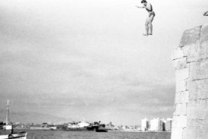 Un grupo de jóvenes lanzándose al mar desde las piedras del fortín del Faro.