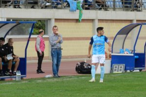 Alberto González observando el juego desde el banquillo junto al capitán celeste Javilillo.