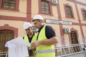 Los obreros revisan los planos de los trabajos que están ejecutando en la estación.