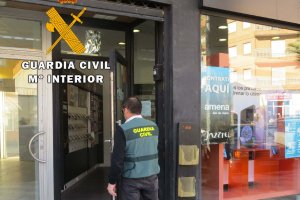 Un agente ante una tienda de telfonía móvil.