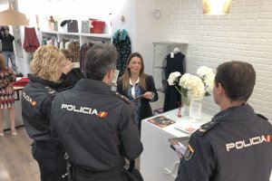 Agentes de la Policía Nacional informan a las dependientas de una tienda de moda en la calle Reyes Católicos de Almería