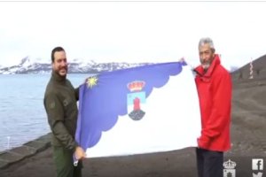 Los dos almerienses portando la bandera de Roquetas en la Antártida.
