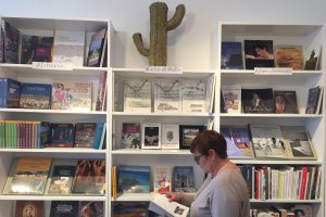 La librera echa un vistazo a una de las obras de su sección dedicada a Cabo de Gata.