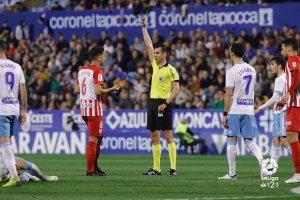 Varón Aceitón mostrando la cartulina amarilla.