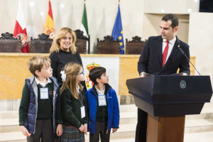 tres jóvenes escolares observan con atención al alcalde