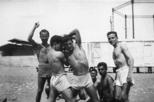 José Plaza , con la mano levantada, haciendo de juez en un combate de lucha en la playa.