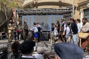 Imagen de la recreación histórica en el Paseo con vecinos vestidos con ropa de los años 20.