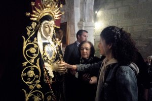 Una de las personas invidentes tocando a la Virgen de la Soledad.