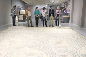 La delegada de Cultura, el alcalde y la concejala de Cultura observando el mosaico romano de Ciavieja.