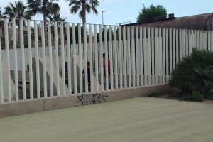 Menores al otro lado de la valla que separa las vías del tren del Parque de la Estación