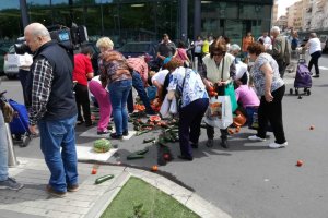 Almerienses cogiendo las verduras arrojadas frente al supermercado.