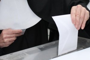 Un votante deposita su sobre en la urna